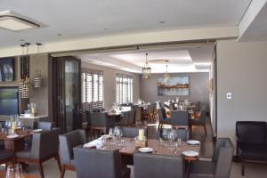 a dining room with tables and chairs in a restaurant at Tredenham Boutique Hotel in Bloemfontein