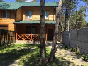 una casa con una recinzione davanti di Cottage in Sosnovom Boru a Kobleve