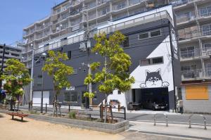 a building with a cat painted on the side of it at Guest House Matsu in Osaka