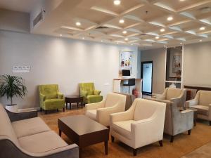 uma sala de espera com sofás e cadeiras e uma mesa em Manhattan Business Hotel TTDI em Petaling Jaya