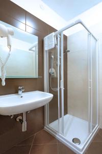 La salle de bains est pourvue d'une douche et d'un lavabo. dans l'établissement Hotel Gelmini, à Vérone