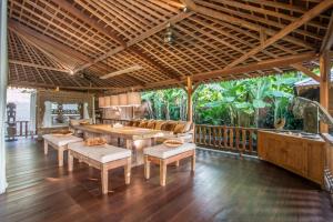 a living room with a table and chairs on a balcony at Marika Sawah Villa in Seminyak
