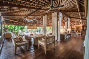 an open living room with a table and chairs at Marika Sawah Villa in Seminyak
