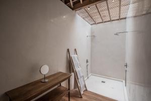 a bathroom with a shower and a wooden table at Marika Sawah Villa in Seminyak