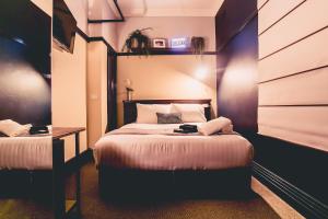a bedroom with two beds and a table in it at The Greenroof in Newcastle