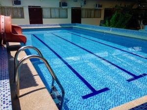 a swimming pool with a red chair next to it at Hotel MundialCity in Guayaquil