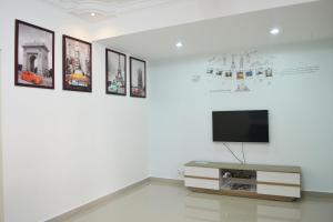 uma sala de estar com televisão numa parede com imagens em Holidays Vacation Suite em Bentong