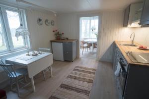 Anfasteröd Gårdsvik - Grindstugan في لجونجسكيل: مطبخ مع مكتب وطاولة مع حوض