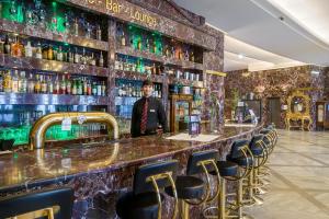 a man standing in front of a bar at Hotel Unique Dortmund Hauptbahnhof in Dortmund