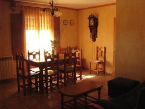uma sala de jantar com mesa e cadeiras e um relógio em Casa Marzo em Angüés