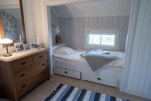 Anfasteröd Gårdsvik - Grindstugan في لجونجسكيل: غرفة نوم صغيرة بها سرير ونافذة