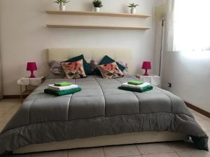 a bedroom with a large bed with green pillows at Appartamento Alla Corte in Venice