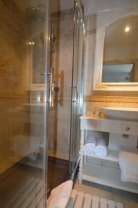 W łazience znajduje się szklana kabina prysznicowa i umywalka. w obiekcie Moulin De Jouenery Et Spa w mieście Brassac