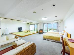 a bedroom with a bed and a living room at Kanehide Onna Marine View Palace in Onna