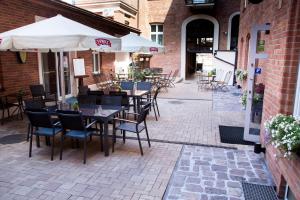 an outdoor patio with tables and chairs and umbrellas at Hotel Maksymilian in Krakow