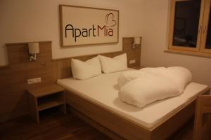 ザーファウスにあるApart Miaの白いシーツと枕が備わるベッド1台が備わる客室です。