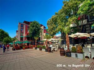 una plaza de la ciudad con mesas, sillas y sombrillas en 4U Apartment - Gurko, en Burgas