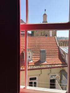 een raam met uitzicht op een tegeldak bij Casa da Sé Cathedral Suites in Coimbra