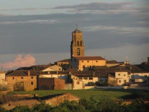 uma cidade com uma torre de relógio no topo de uma colina em Casa Marzo em Angüés