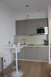a kitchen with white cabinets and a sink and a table at Eve in Cannes