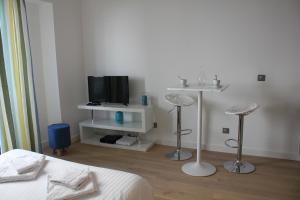 a bedroom with a bed and a tv and two stools at Eve in Cannes