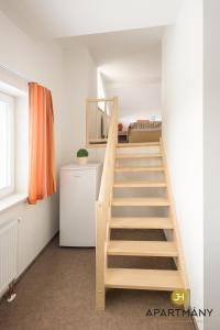 - un escalier en bois dans une chambre avec un lit dans l'établissement Apartmány Jindřichův Hradec, à Jindřichův Hradec