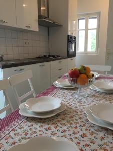 a table with plates and a bowl of fruit on it at Apartment Eva Kali in Kali