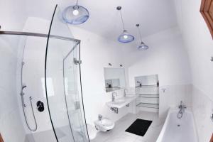 a bathroom with a shower, sink, and toilet at Hostel HOMEr - Old Town Square in Prague