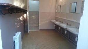 a bathroom with three sinks and two mirrors at Camping de la minière in Forges-les-Eaux