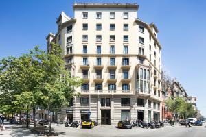 um edifício alto e branco com motos estacionadas em frente em Fisa Rentals Shopping em Barcelona