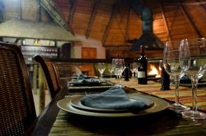 a table with a plate of food and wine glasses at Baobab Lane Lodge in Marnitz