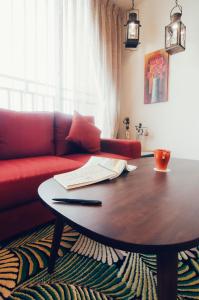 Una sala de estar con una mesa y un sofá rojo. en Zai Yan Yan 259 B&B, en Jian