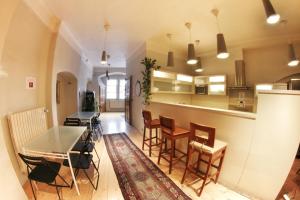 cocina y comedor con mesa y sillas en Hostel HOMEr - Old Town Square, en Praga