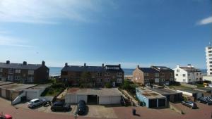 a group of buildings with the ocean in the background at @Juliette in Zandvoort
