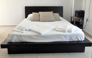 a large bed with white sheets and pillows on it at Marine House Andrianna -Adults only in Siviri