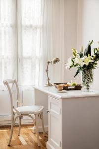 a white desk with a chair and a vase of flowers at Hotel Infanta Isabel by Recordis Hotels in Segovia