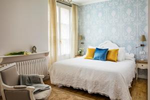 a bedroom with a bed and a chair at Hotel Infanta Isabel by Recordis Hotels in Segovia