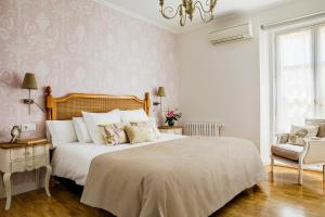 a bedroom with a large white bed and a chair at Hotel Infanta Isabel by Recordis Hotels in Segovia
