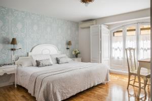 a bedroom with a white bed and a table and a desk at Hotel Infanta Isabel by Recordis Hotels in Segovia