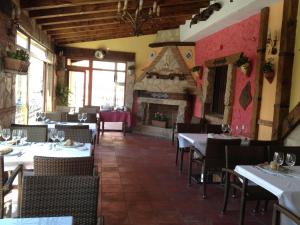 a restaurant with tables and chairs and a fireplace at Hotel Algete in Algete