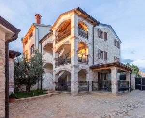 a large brick building with a balcony on it at Apartments P&B in Vabriga
