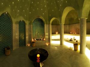 
a large room with a large fountain in the middle of it at Palais Faraj Suites & Spa in Fez
