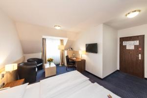 ケルンにあるノヴム ホテル マリエラ エアポートのベッドとデスクが備わるホテルルームです。