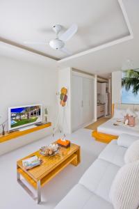a white living room with a white couch and a table at Chi Samui Resort in Bophut