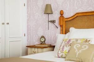 a bedroom with a bed with a clock on a table at Hotel Infanta Isabel by Recordis Hotels in Segovia