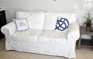a white couch with a laptop on top of it at Marine House Andrianna -Adults only in Siviri