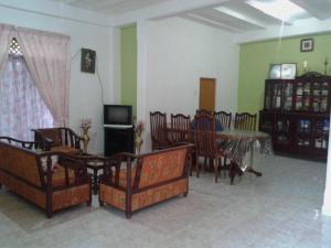ein Wohnzimmer mit Tisch und Stühlen und einem Fernseher in der Unterkunft Didula Holiday Resort in Anuradhapura