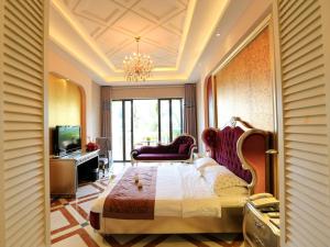 - une chambre avec un lit et un lustre dans l'établissement Palm Beach Resort & Spa, à Sanya