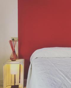 a bedroom with a white bed and a red wall at Residence del Golfo in Castellammare del Golfo
