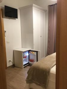 a room with a tv and a small refrigerator at Il giardino di Daniela in San Teodoro